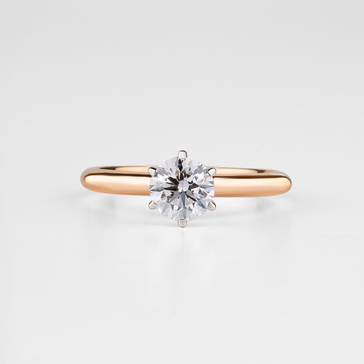 Solitaire ring with a round faceted centre stone on a pale background