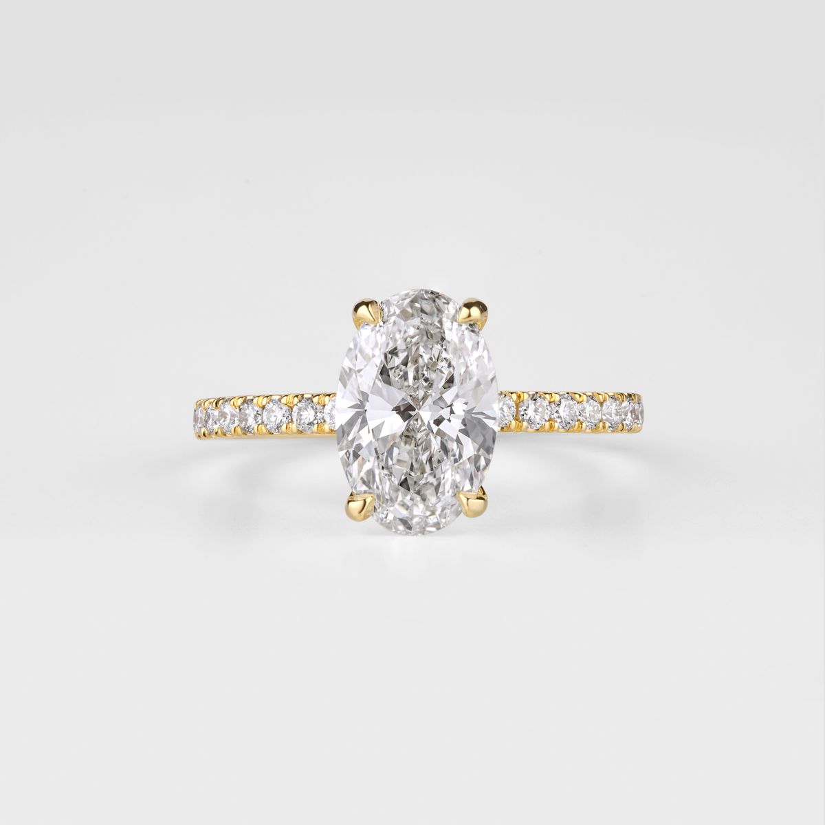 Oval diamond ring with warm gold detailing and a polished finish