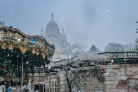 白雪皑皑的巴黎蒙马特为背景，圣心大教堂化作旋转木马，构成一幅迷人的冬季场景