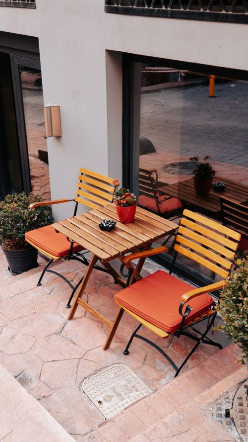 Free Charming outdoor seating area with wooden table and chairs for a cafe ambiance. Stock Photo