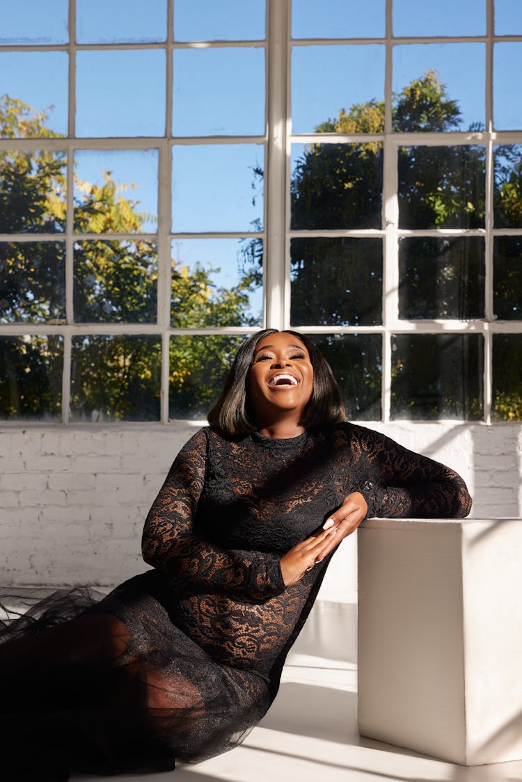 Laughing Woman Sitting And Laughing In Black Dress