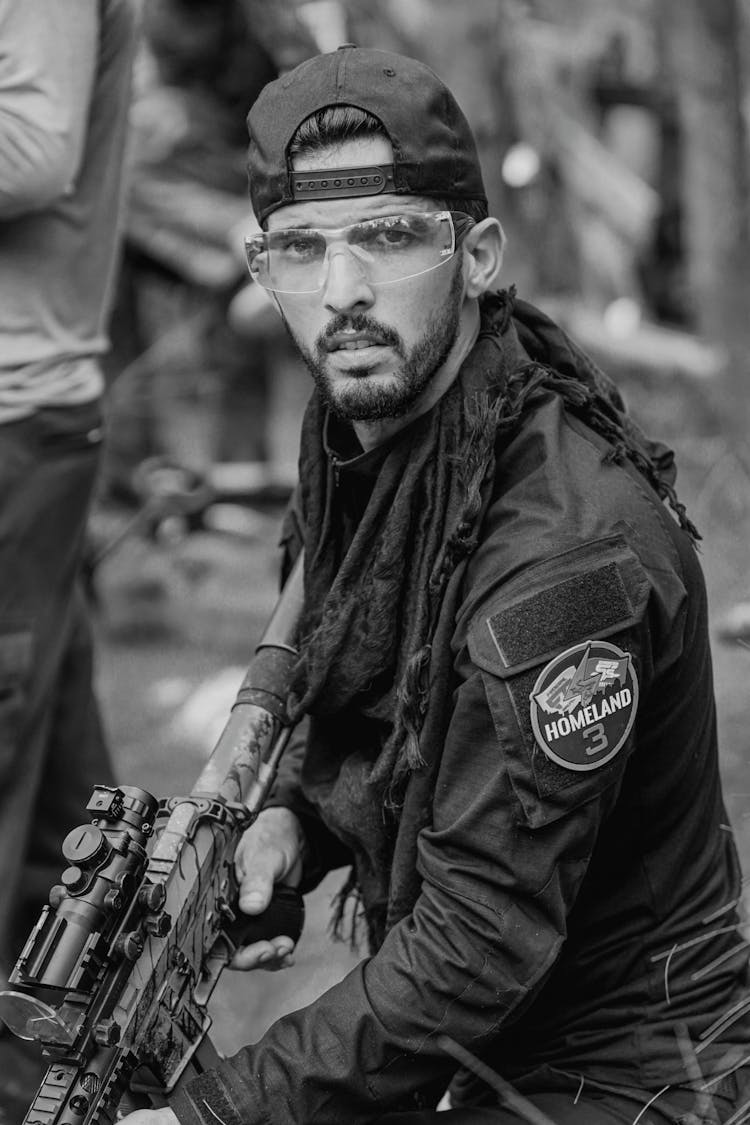 Grayscale Photo Of Man Holding A Rifle