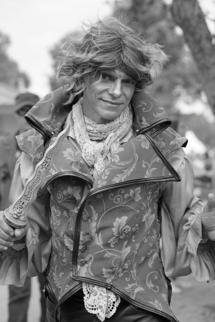 Black And White Photo Of Man Wearing Elaborate Costume Holding Dagger