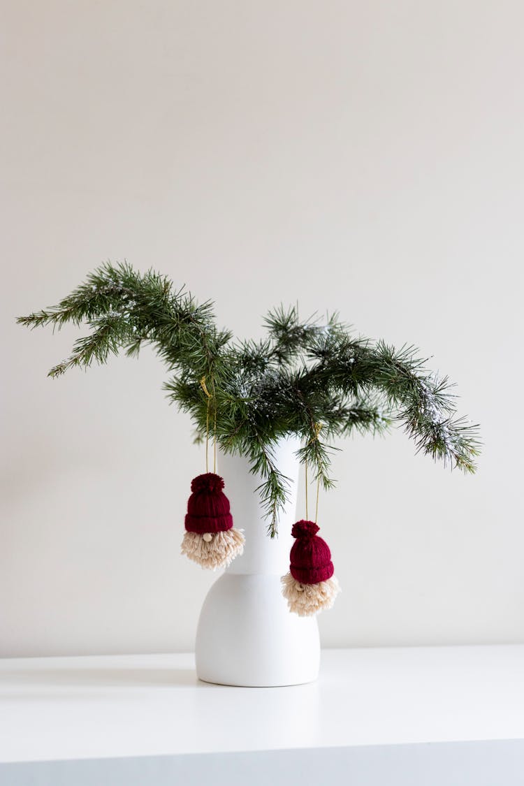 Christmas Decorations Hanging From Conifer Twigs In A Vase