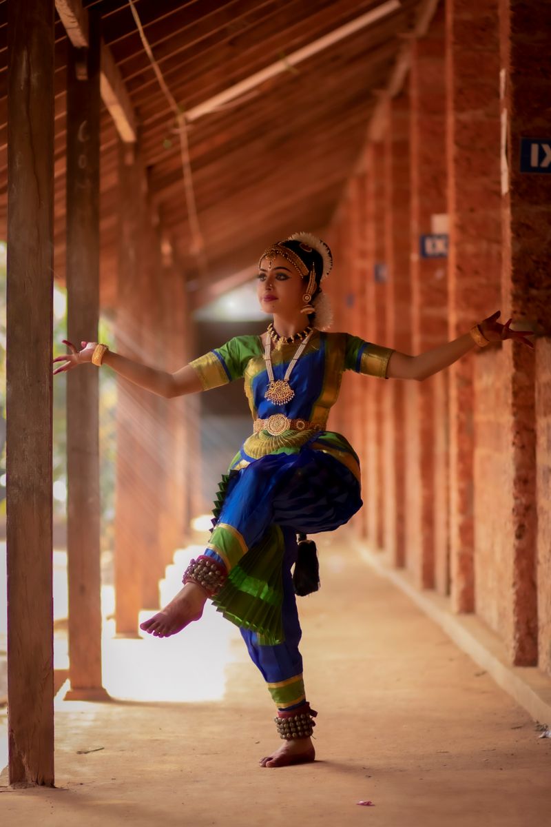 A graceful Indian woman performing classical dance in warm light