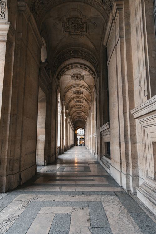 Free Explore the architectural beauty of the Louvre Museum's arched hallway in Paris. Stock Photo