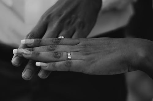 Grayscale Photo of a Person's Hand with a Ring