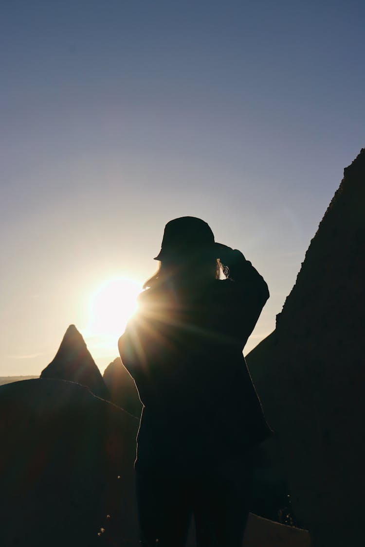 Woman Facing Sunset In Mountains