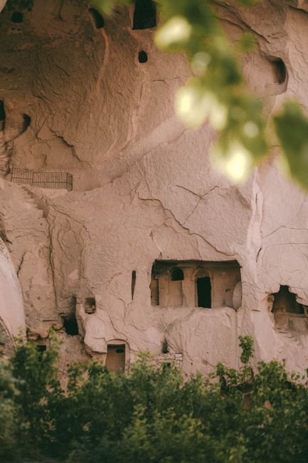 Explore the historic cave formations of Cappadocia, Turkey, nestled in a lush landscape.
