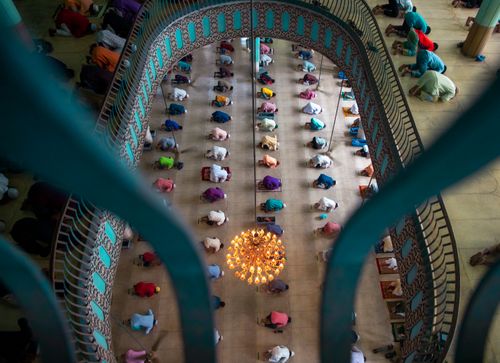 Free Muslims performing Salah in a mosque, viewed from above, in Dhaka, Bangladesh. Stock Photo