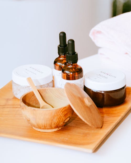 Jars with Cream and Essential Oils in Droppers by Bowl