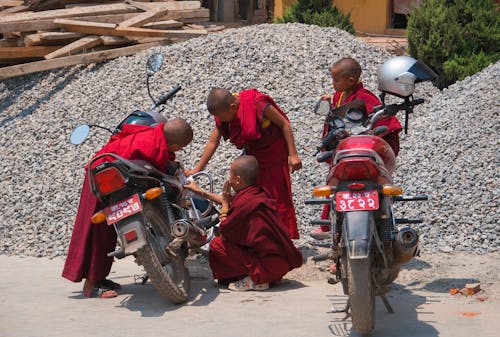 Boys in Gowns Looking at Motorcycles 