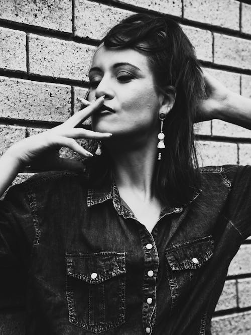 Grayscale Photo of Woman Smoking Cigarette