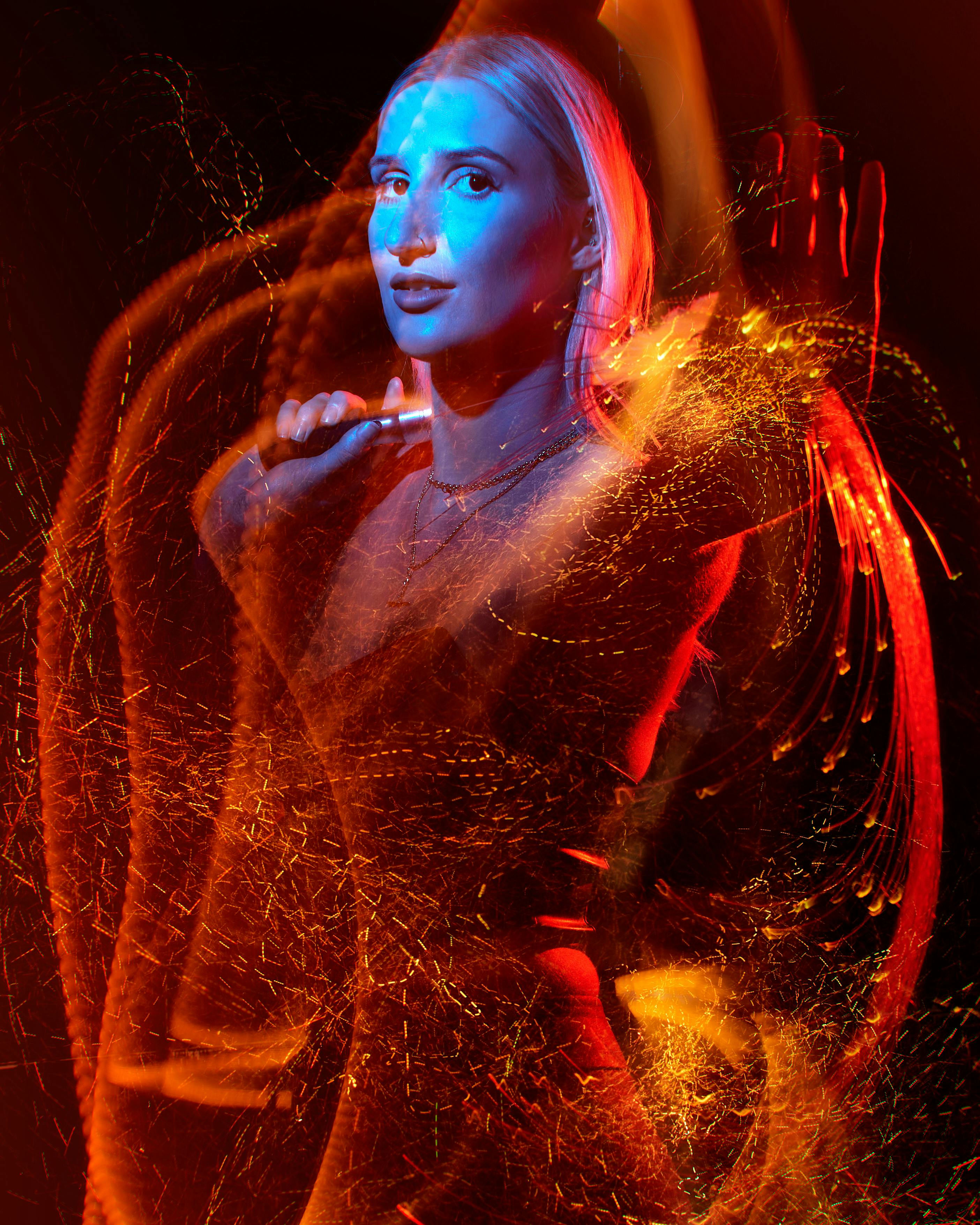 A creative portrait of a woman with expressive light trails in red and blue hues.
