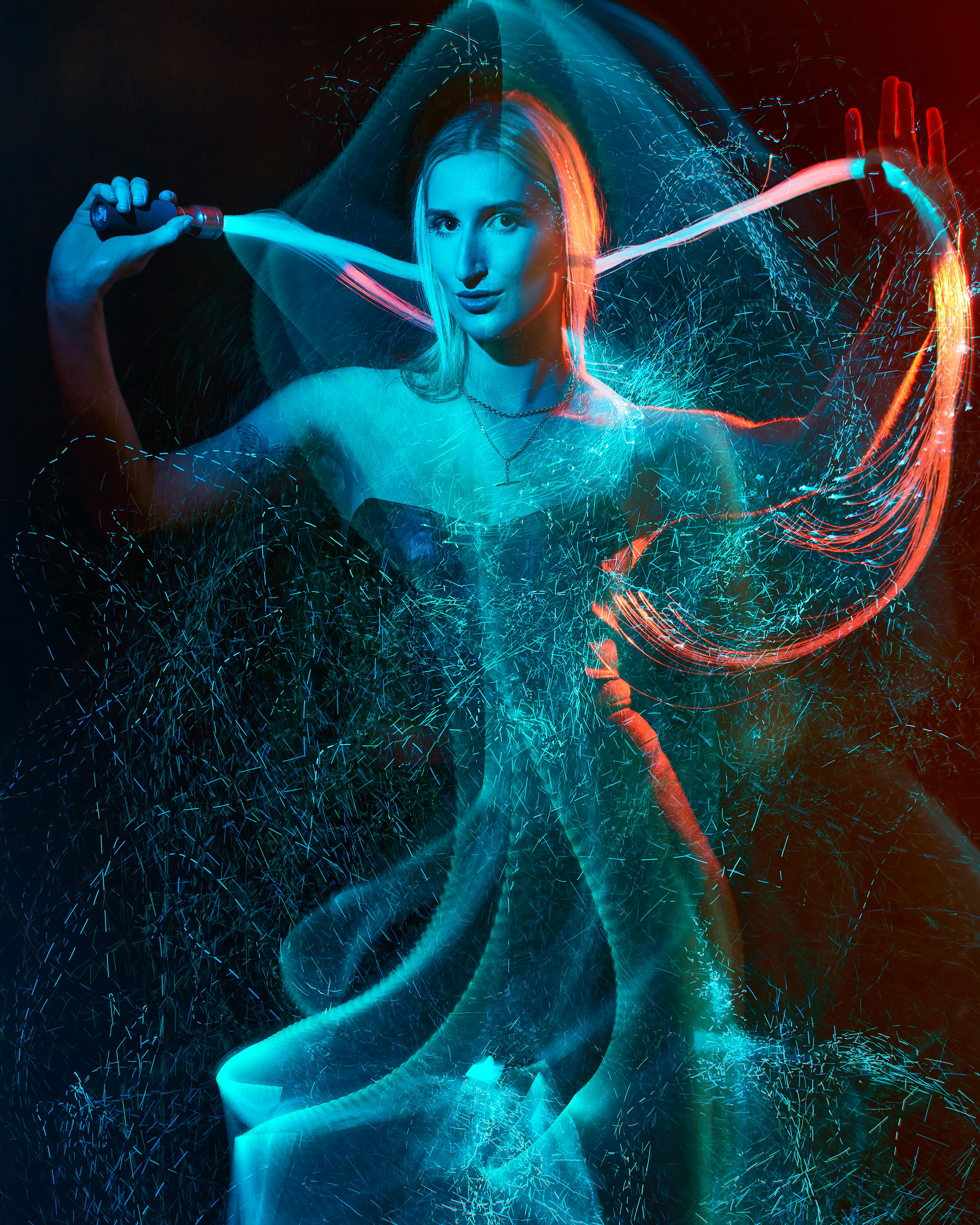 Artistic light painting photography featuring a woman with colorful trails and vibrant effects.