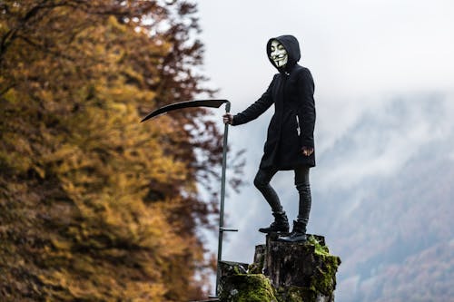 Persoon Die Guy Fawkes Masker Draagt Terwijl Hij Zeis Vasthoudt