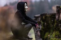 Photo of Person in Black Hoodie and White Mask