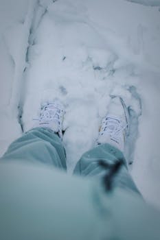Close-up of white sneakers on fresh snow, capturing a wintry feel and snowy texture.