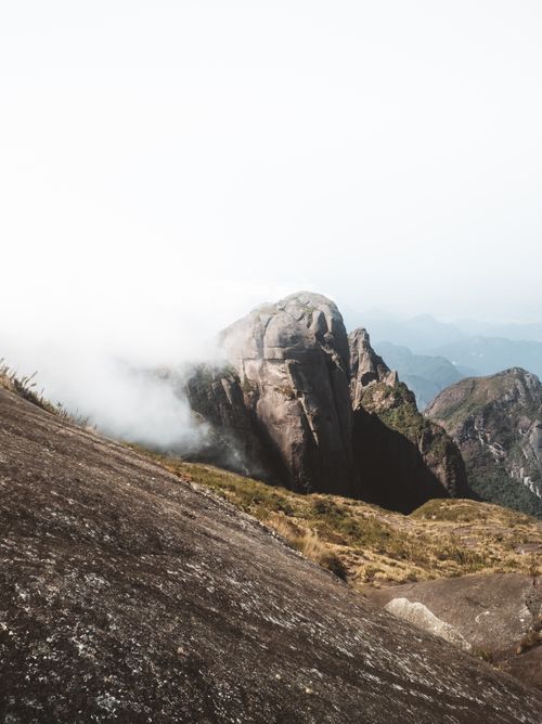 Free Serene foggy mountain landscape featuring large rocks and misty atmosphere on a cloudy day. Stock Photo