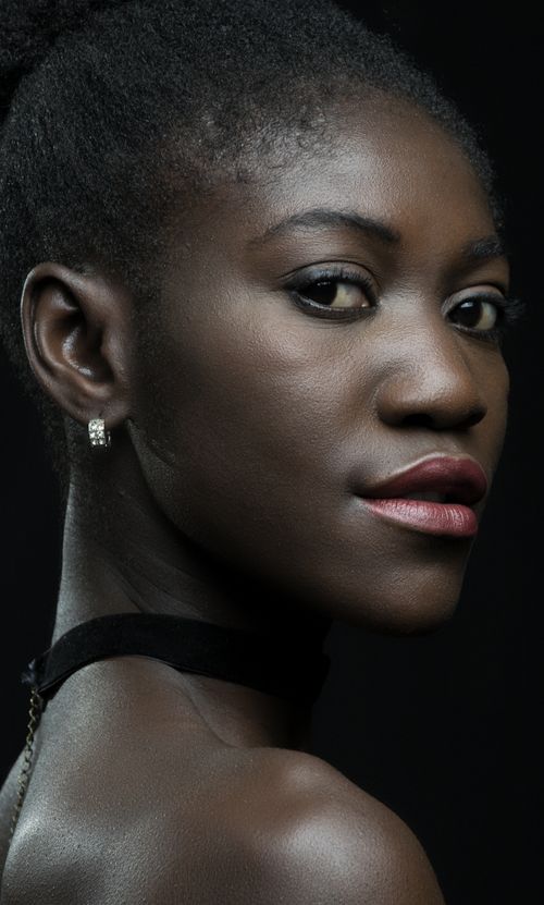 Free Stunning portrait of a woman with a serious expression showcasing elegance and style. Stock Photo