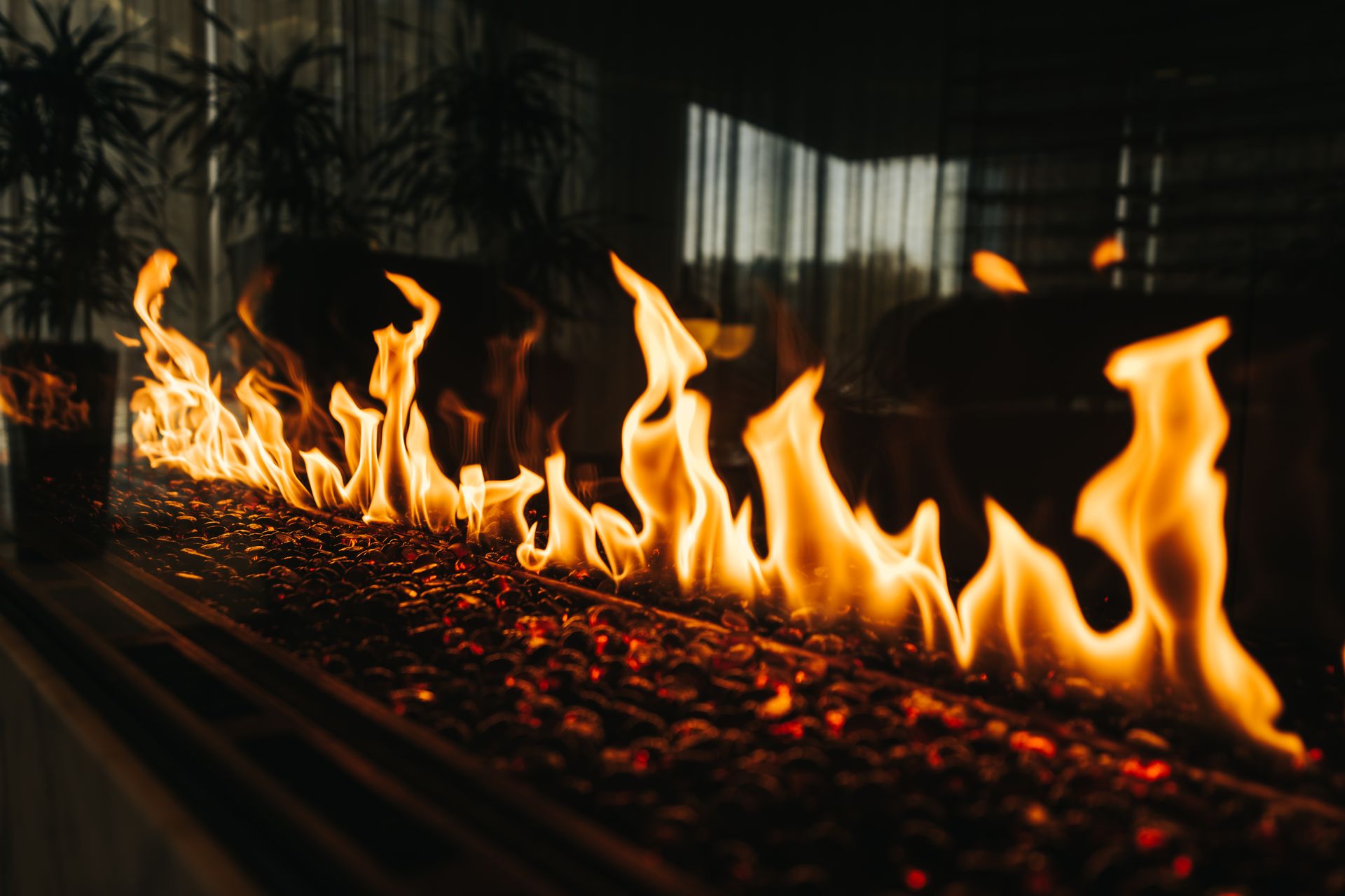 Close-up of vibrant flames dancing over embers in an indoor fireplace setting.