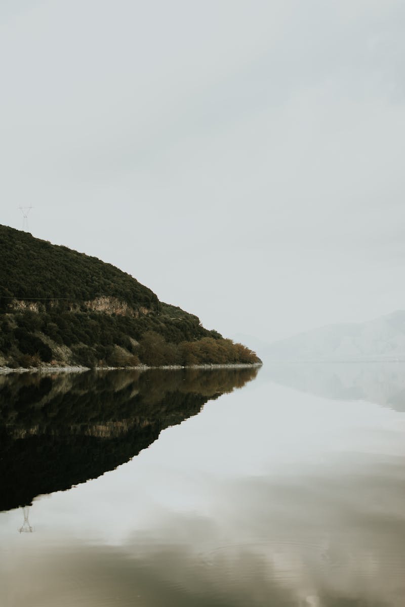 A serene misty landscape with a perfect reflection on a tranquil lake, capturing the essence of nature