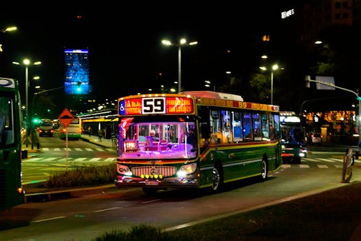 Brightly lit bus on Buenos Aires city street at night, showcasing urban transport.