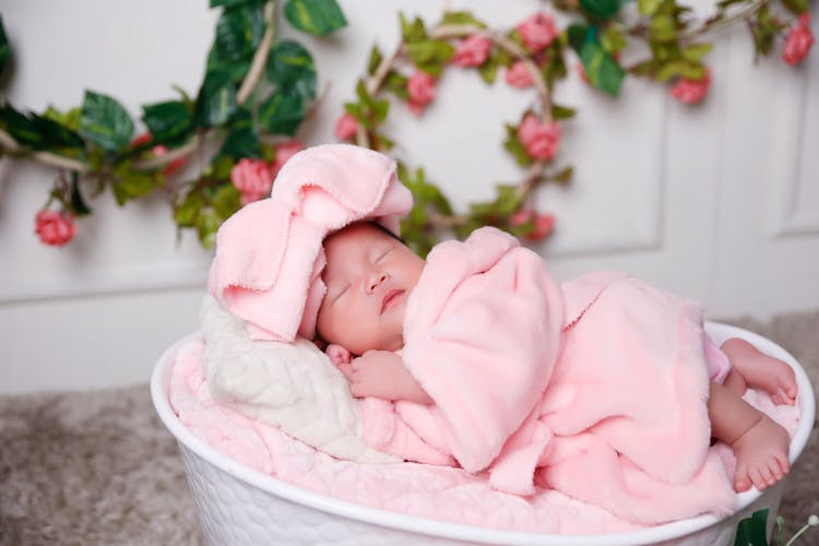 A Cute Baby In Pink Robe Sleeping