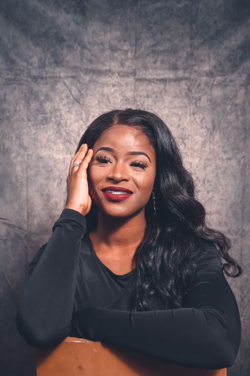 Free Studio portrait of a smiling African woman with long hair against a textured background. Stock Photo