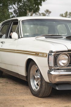 Close-up of a white classic Ford car parked outdoors highlighting its vintage style.