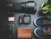 相机设备、智能手机、笔记本电脑、鞋子和植物被创意性地平放在一起