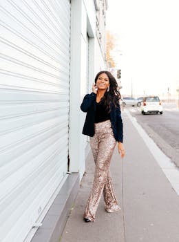 Stylish woman in glitter pants walking confidently on a city street, exuding modern urban fashion.