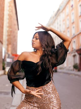 Fashionable woman posing confidently in a stylish outfit on a sunny urban street.