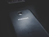 智能手机在深色木制表面上的详细视图，突出显示其标志