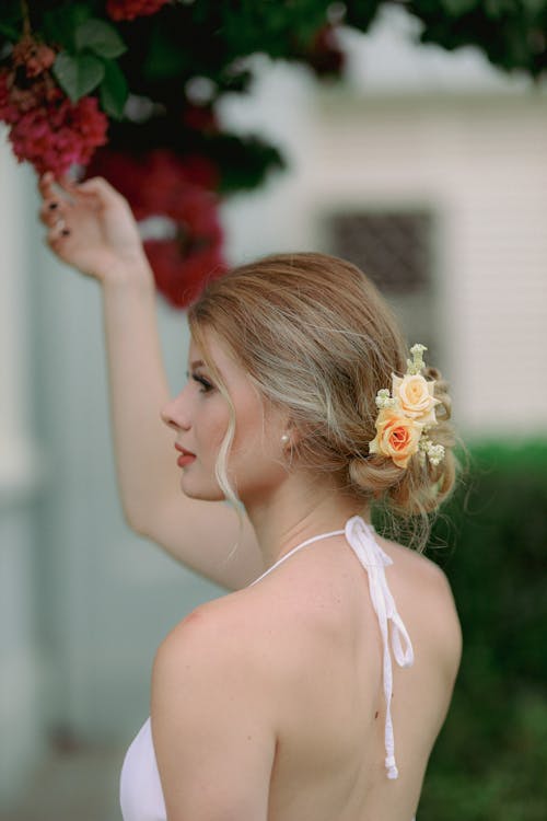 Young Woman Reaching for Bloom from Tree