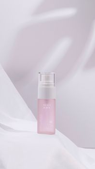 Elegant skincare product displayed in a minimalist setting with soft pink tones and neutral background.