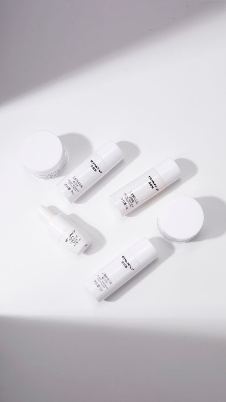Overhead view of minimalistic skincare products on a white background, creating a clean aesthetic.