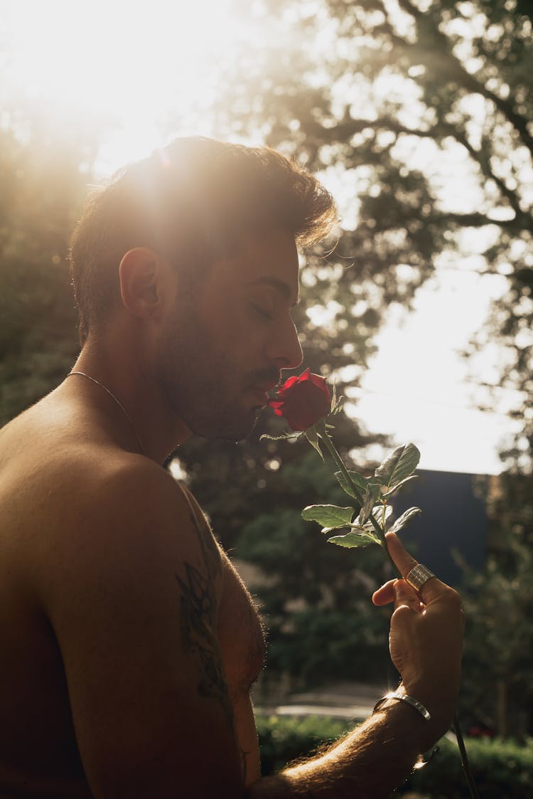 Shirtless Man Smelling Rose