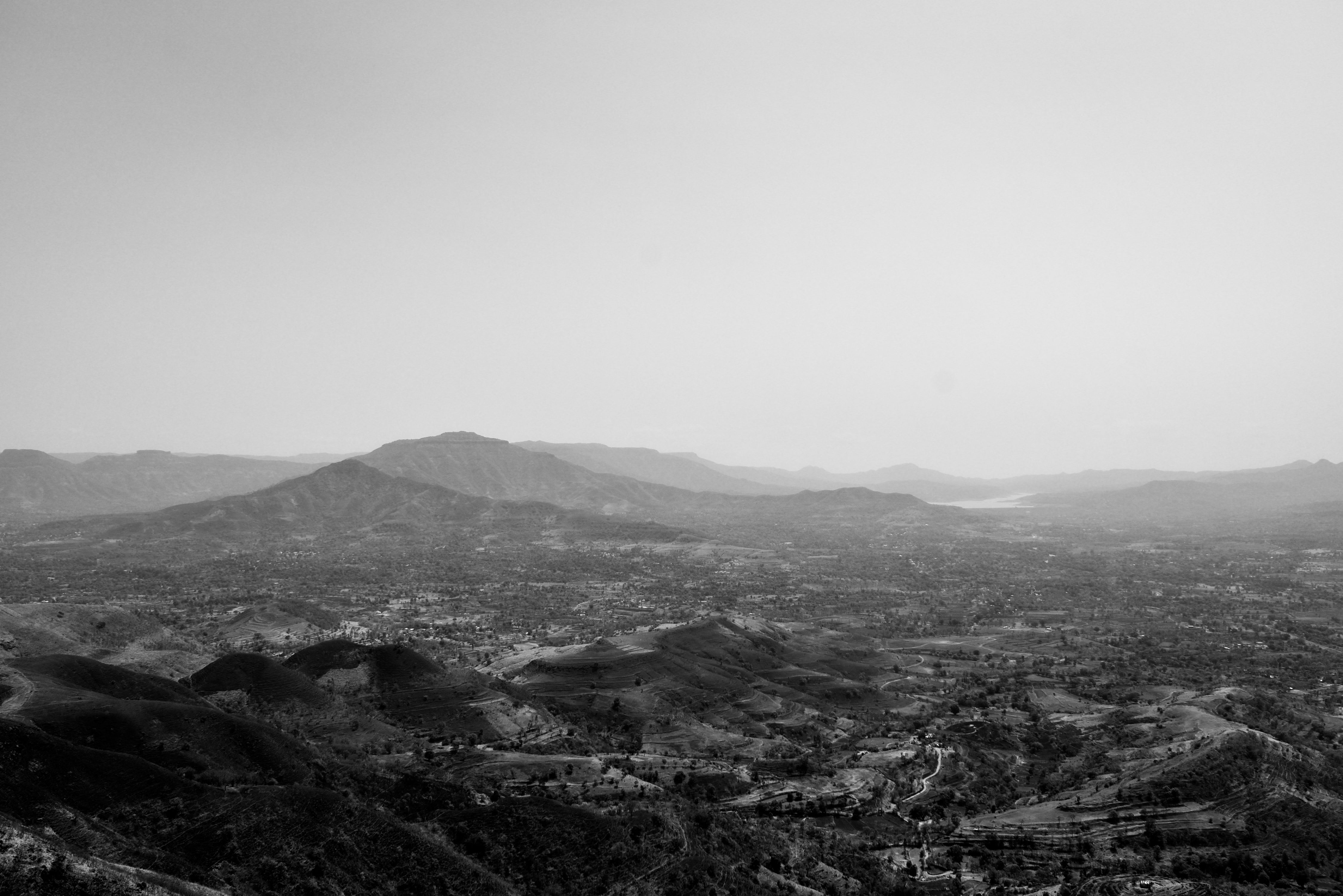 Expansive black and white view of a mountain range in a rural setting, capturing serene nature and scenic beauty.