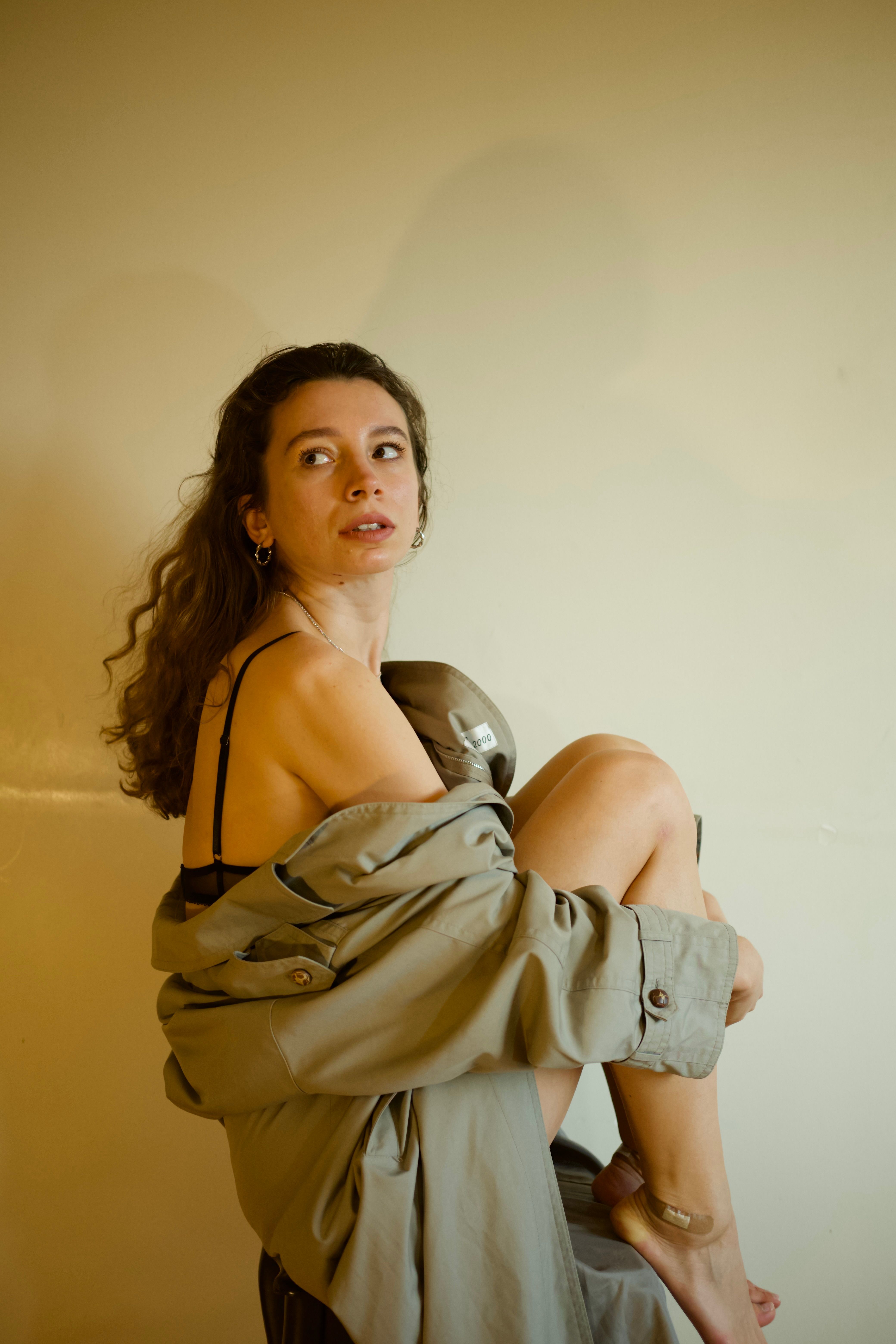 Woman in Brown Coat Sitting on Chair · Free Stock Photo