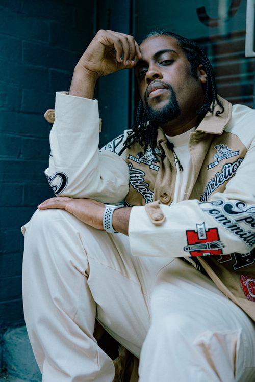 Free Confident man with braids in casual attire posing outside. Stock Photo
