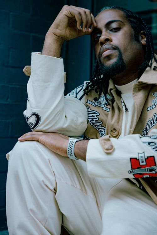Free Fashionable man in streetwear with braids posing stylishly outdoors. Stock Photo