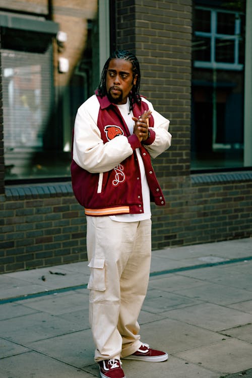 Man in Red and White Jacket Standing on the Street