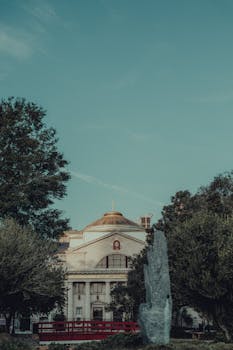 Beautiful view of a historic church with a dome surrounded by trees and stone in a tranquil park.