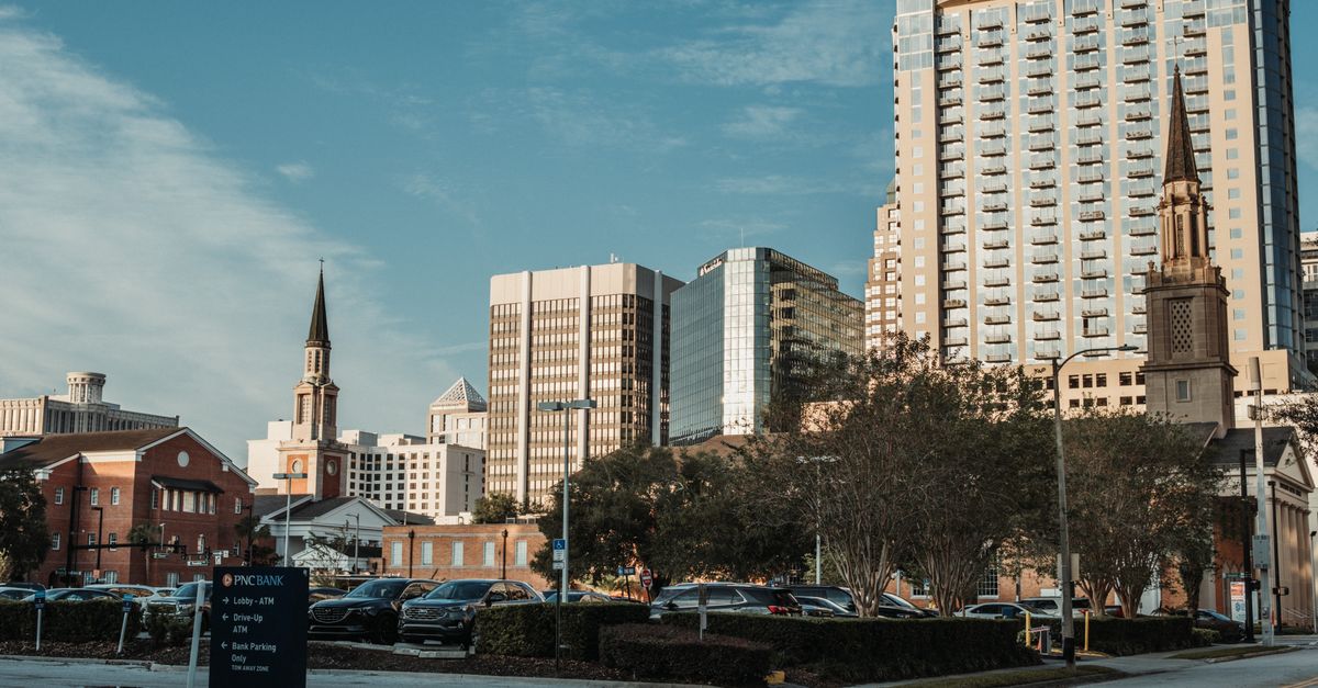 Cityscape featuring tall buildings with a blue sky backdrop, ideal for urban themes.