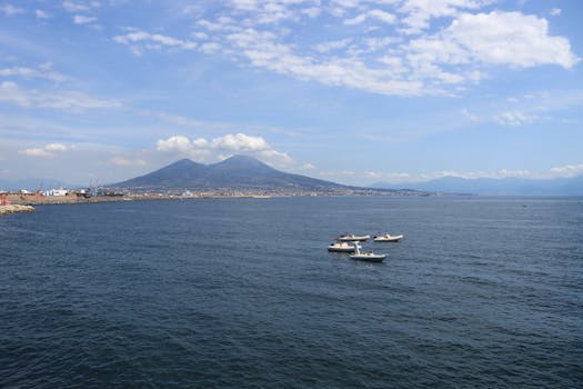 A stunning aerial view of Mount Vesuvius with boats sailing through the picturesque Bay of Naples.