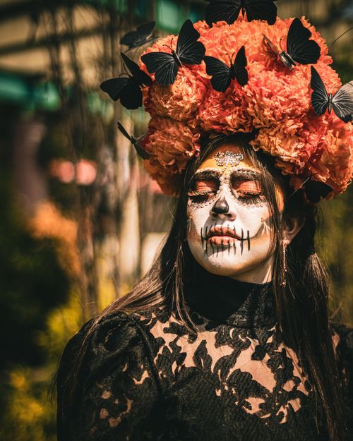 Free Young woman with painted face and flower crown celebrates Dia de los Muertos. Stock Photo