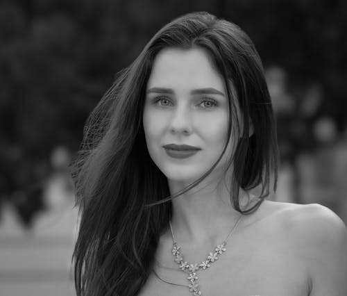 A Grayscale Photo of a Beautiful Woman Wearing Necklace