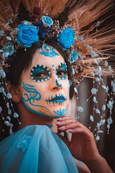 Colorful portrait of a woman with Day of the Dead makeup and floral wreath.