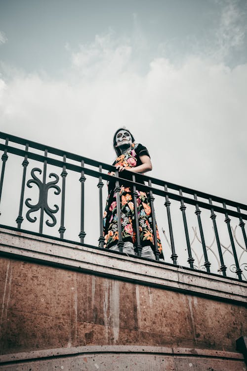 Low Angle View of Woman Wearing Skull Makeup Standing on Bridge